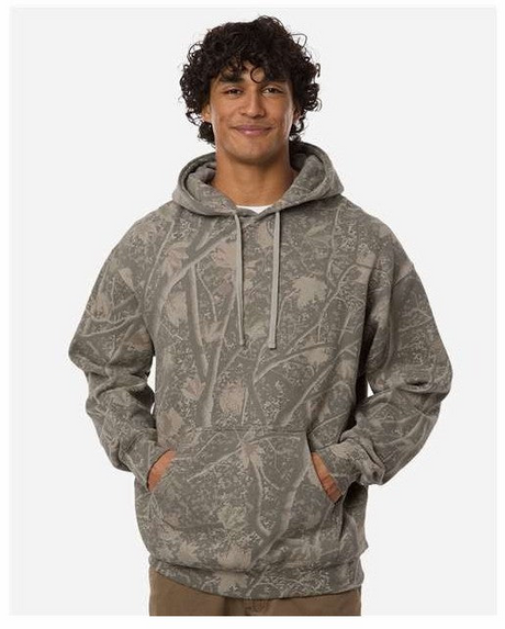 A man wearing a gray camouflage hoodie with a tree branch print, standing against a light gray background.