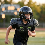 Youth football player wearing a Schutt helmet and shoulder pads on a grassy field during practice