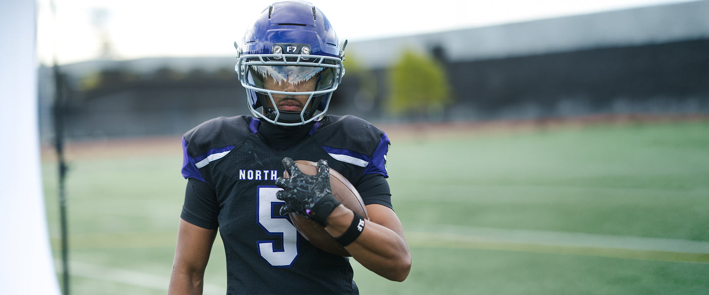 Person in football uniform with helmet and number 5 on a field